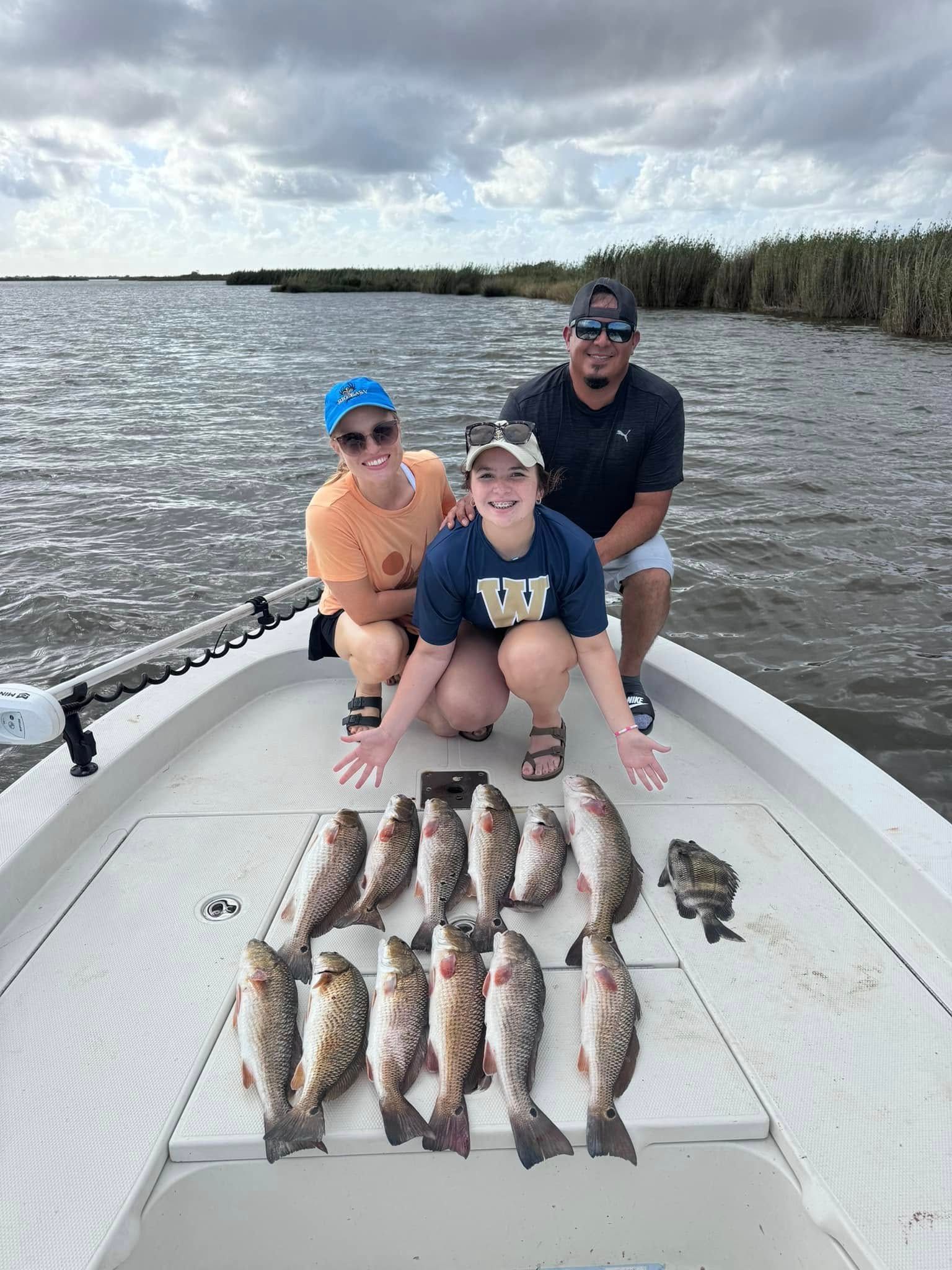 A man and a woman are holding a large fish on a boat.