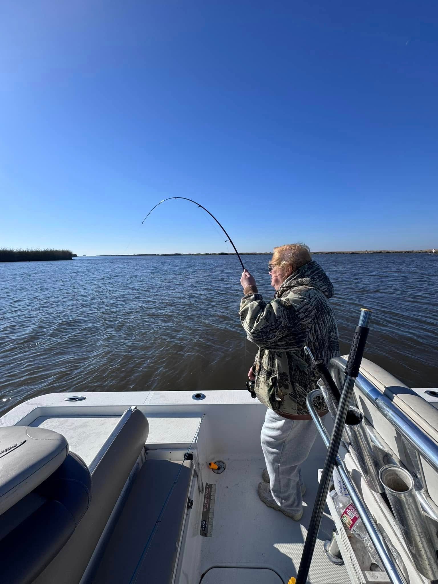 A man is fishing on a boat in the water.