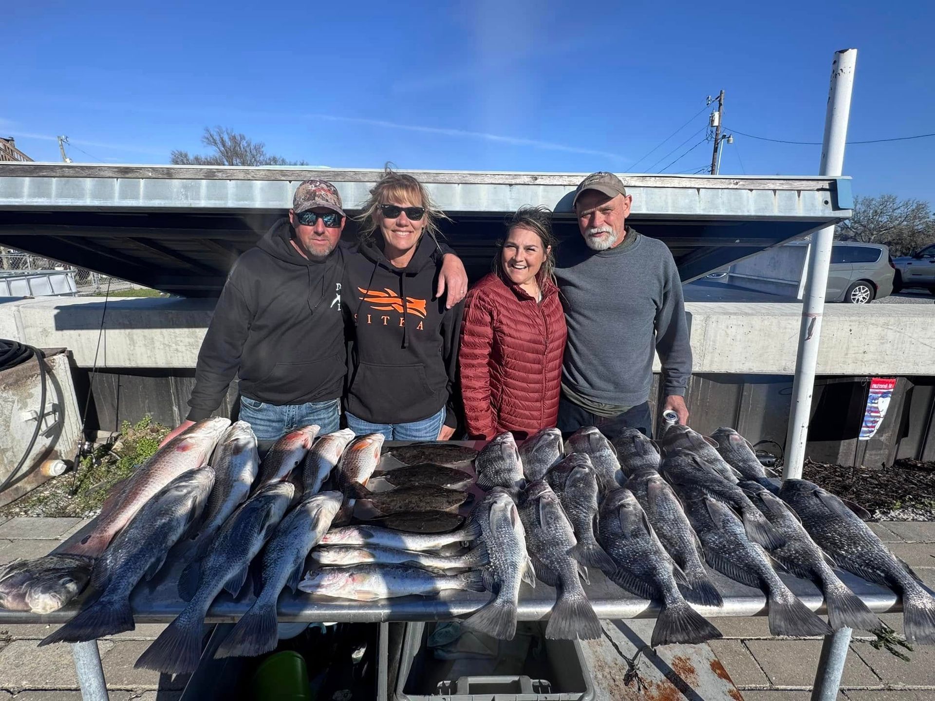 A group of people standing next to a table full of fish.