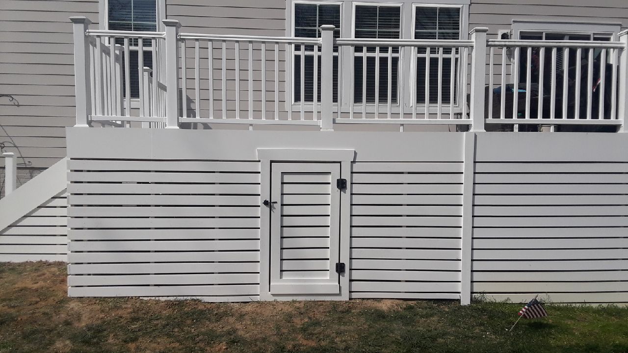 A white picket fence with pink roses growing on it.