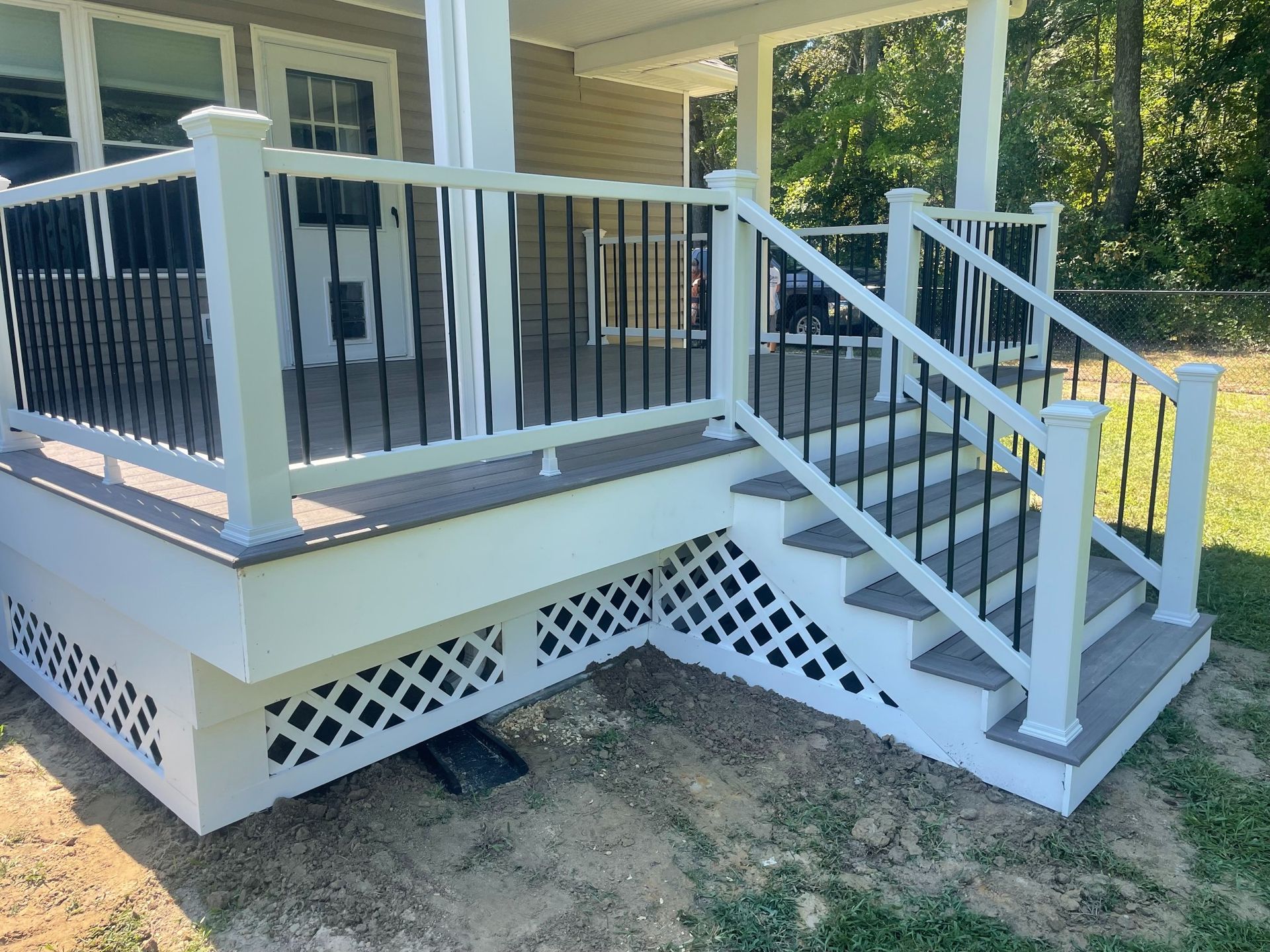 Deck with white railing, black spindles, and steps leading down.