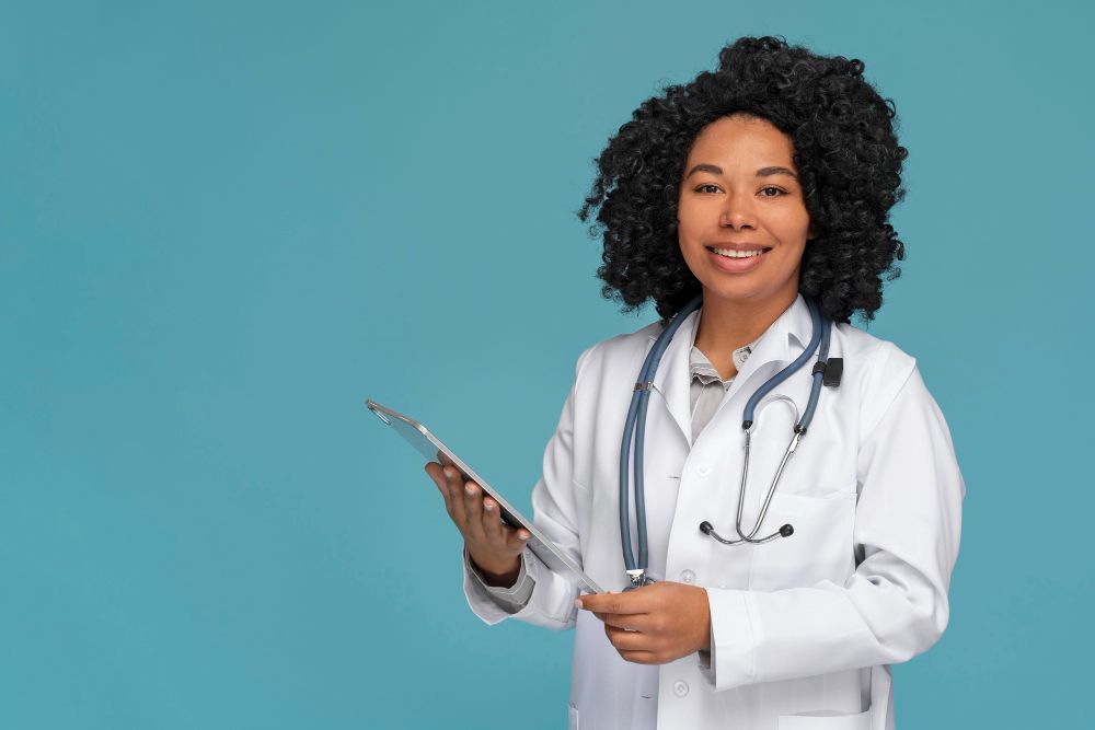 Medico com estetoscópio e jaleco sorrindo com prancheta na mão
