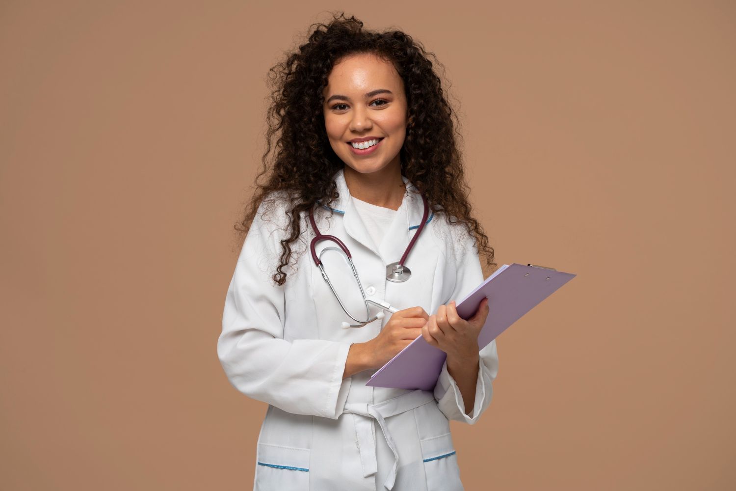 Medico com estetoscópio e jaleco sorrindo com os braços cruzados