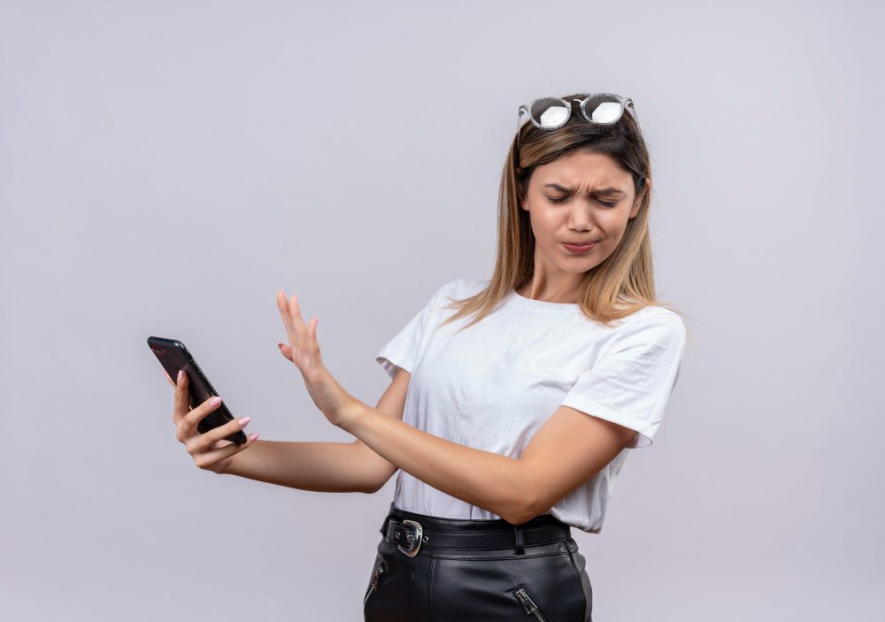 garota com oculos na cabeça recusando celular