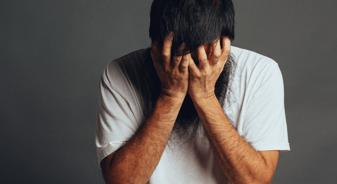 homem desesperado com mãos no rosto
