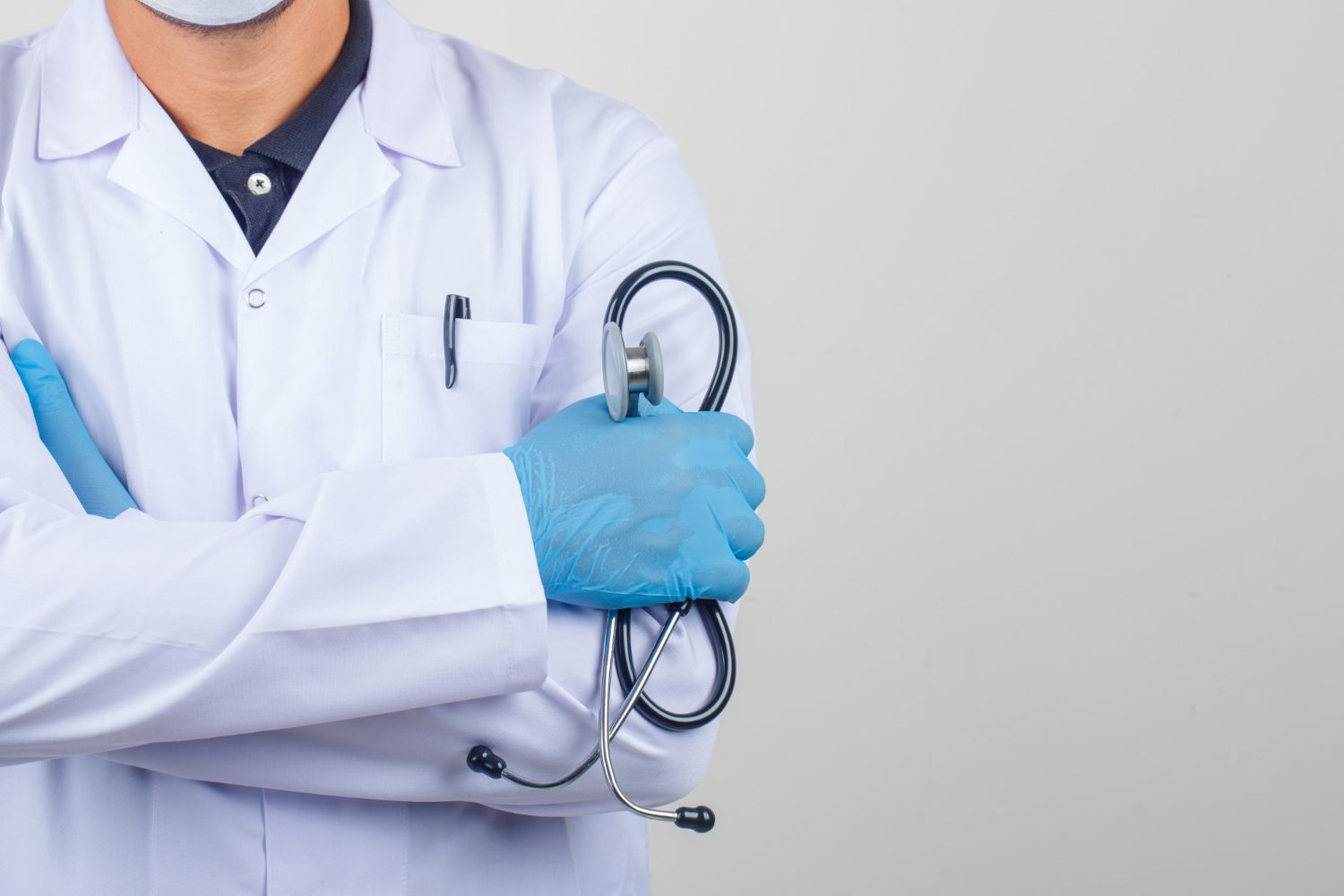 Médico de jaleco branco com luvas e estetoscópio cruzado no peito, apoiando a campanha Junho Vermelho.