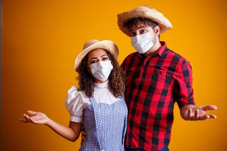 casal com trajes de festa junina com mascara 