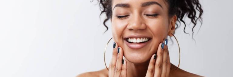 mulher com brincos de argola grandes sorrindo com fundo branco