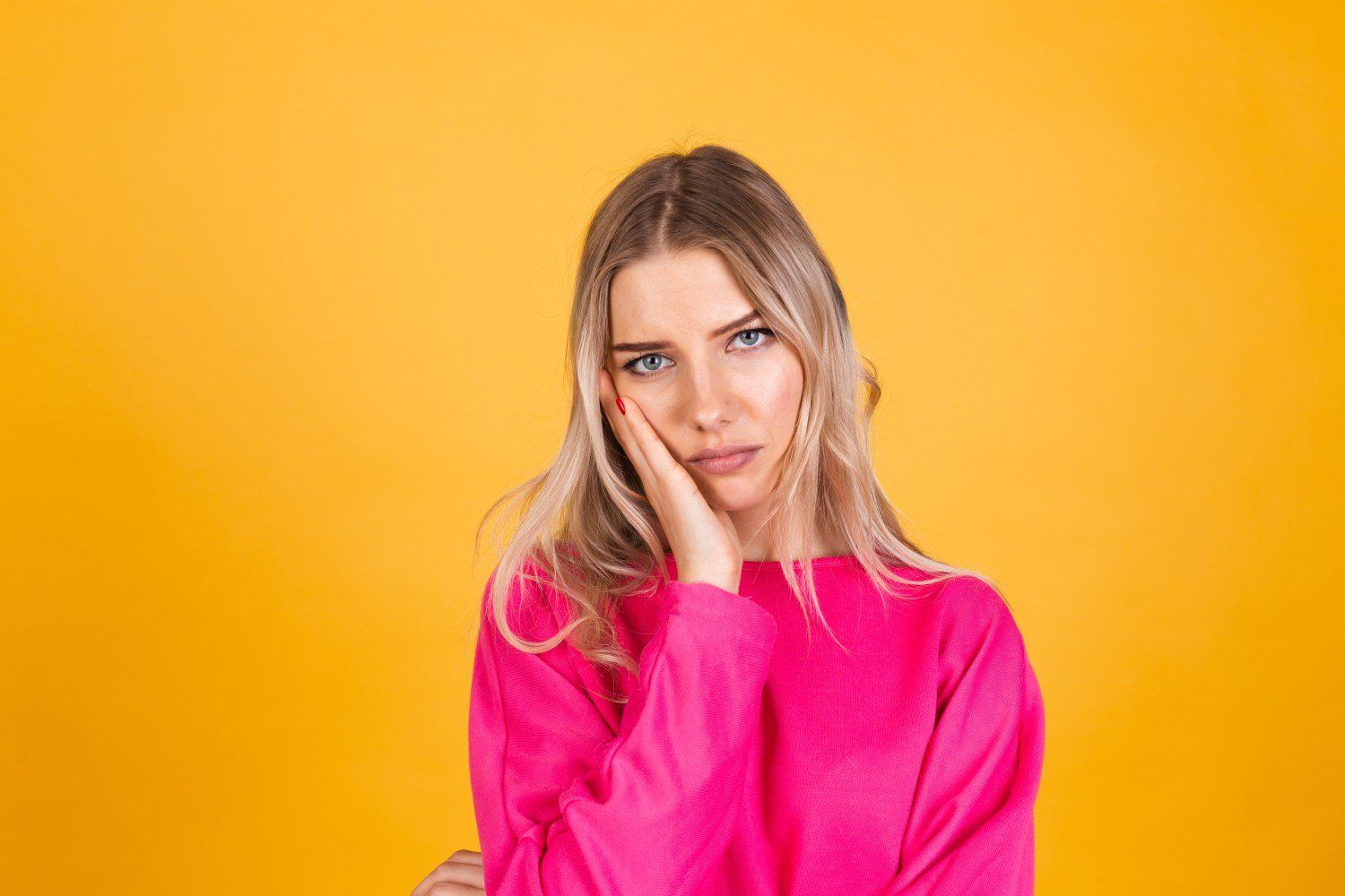 mulher vestida de rosa com dor de dente
