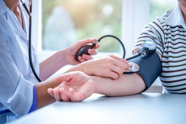médico medindo pressão de paciente