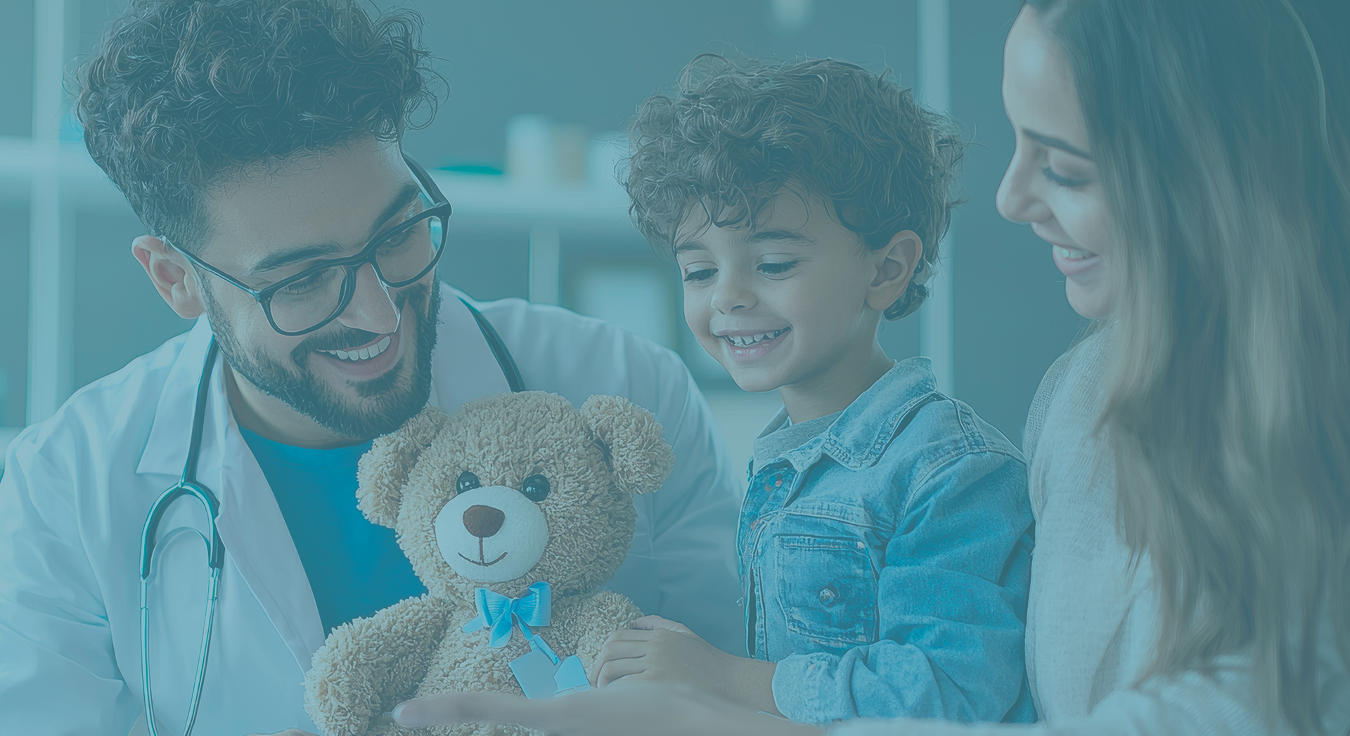 Médico sorridente mostrando urso de pelúcia para criança enquanto mãe acompanha, simbolizando atendimento infantil acolhedor