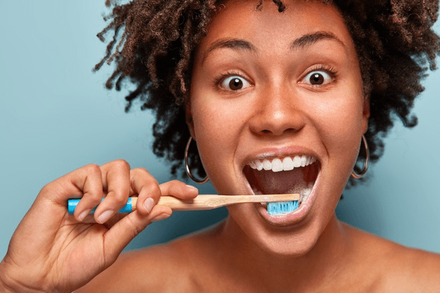mulher muito animada escovando os dentes