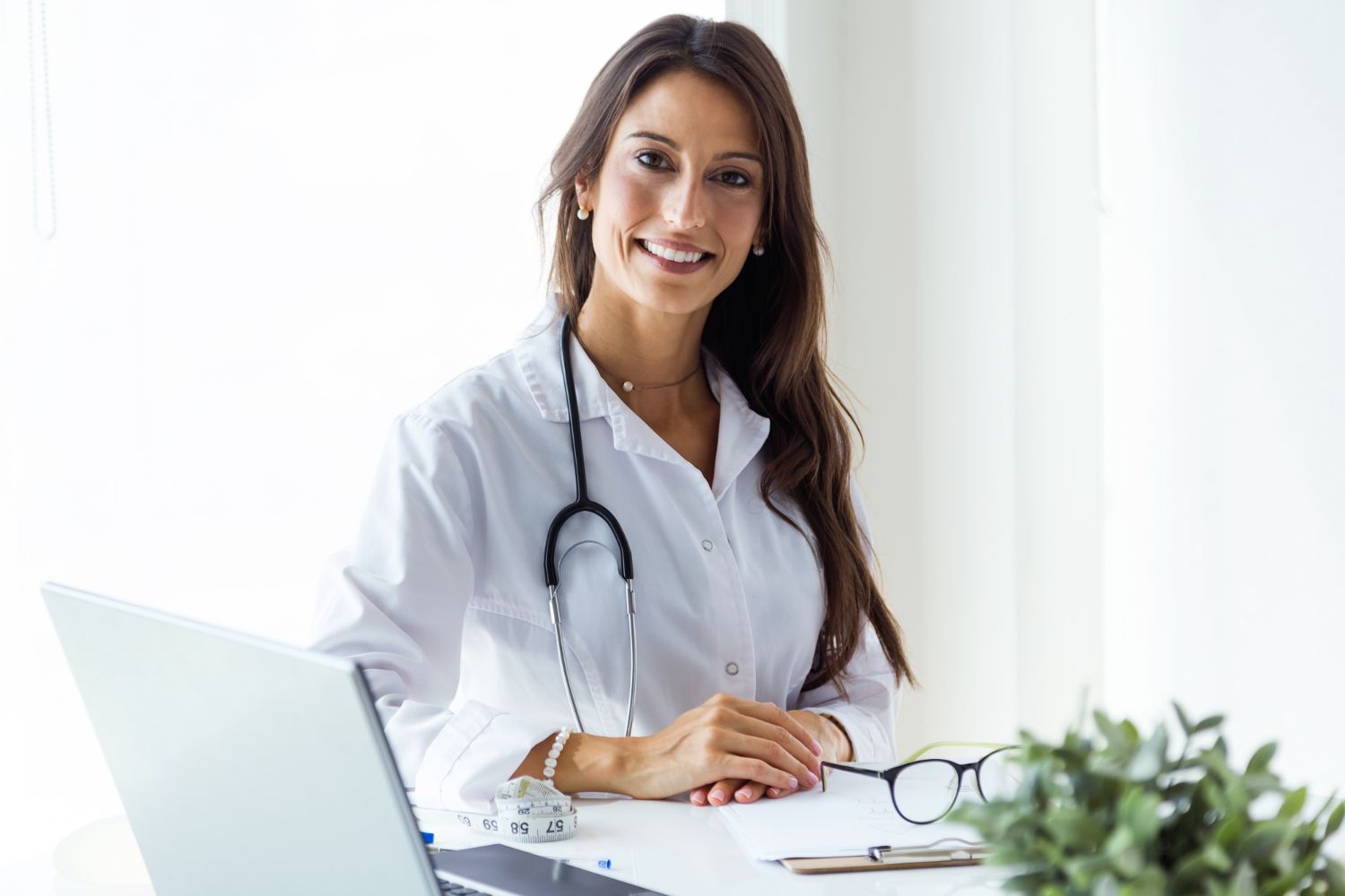 médica com jalecos e equipamentos sorrindo 