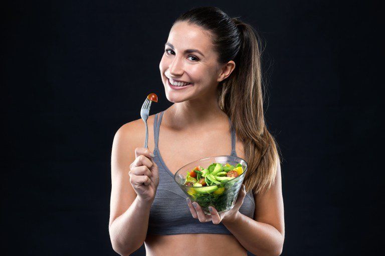 garota segurando pote com salada deliciosa