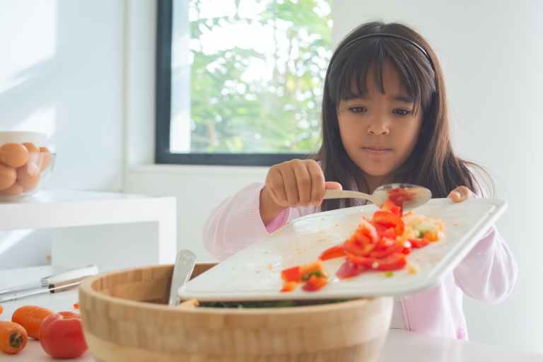 garota cozinhando algo com tomates 