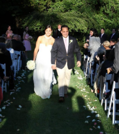 Bride and groom walking down an outdoor aisle during a wedding ceremony
