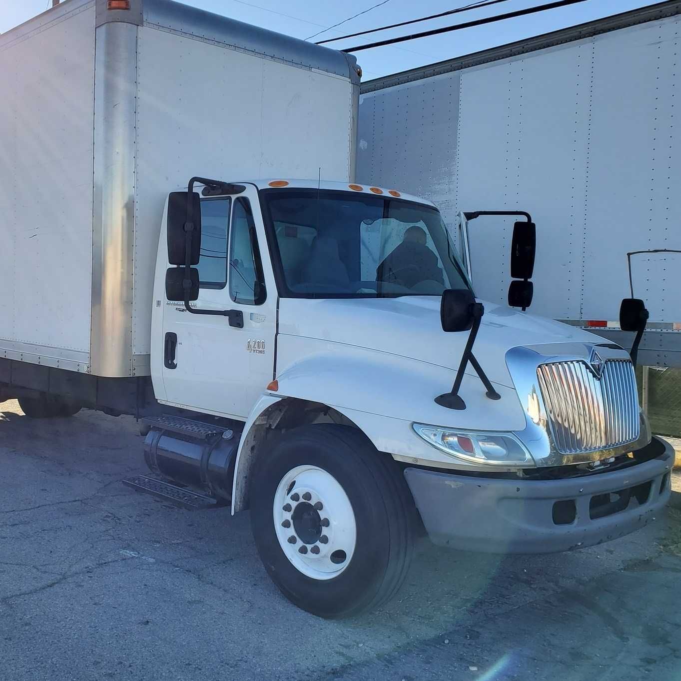 White International box truck parked outside on a sunny day.