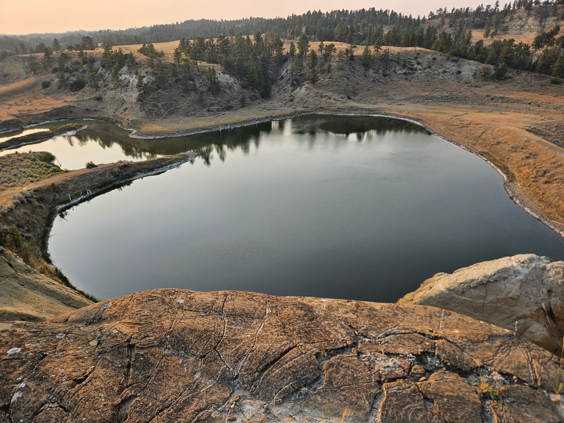 A large body of water surrounded by rocks and trees