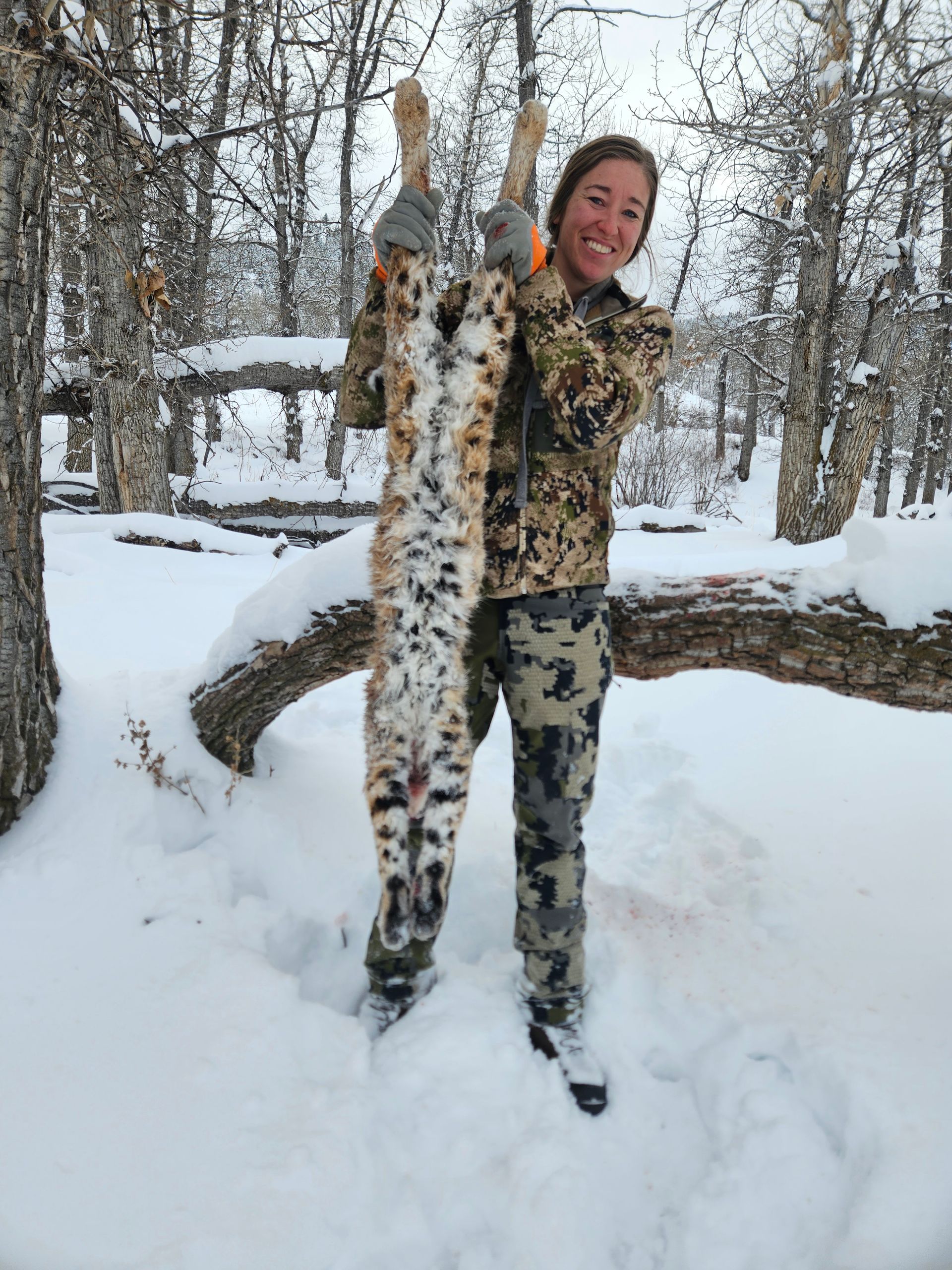 A man holding a dead bobcat