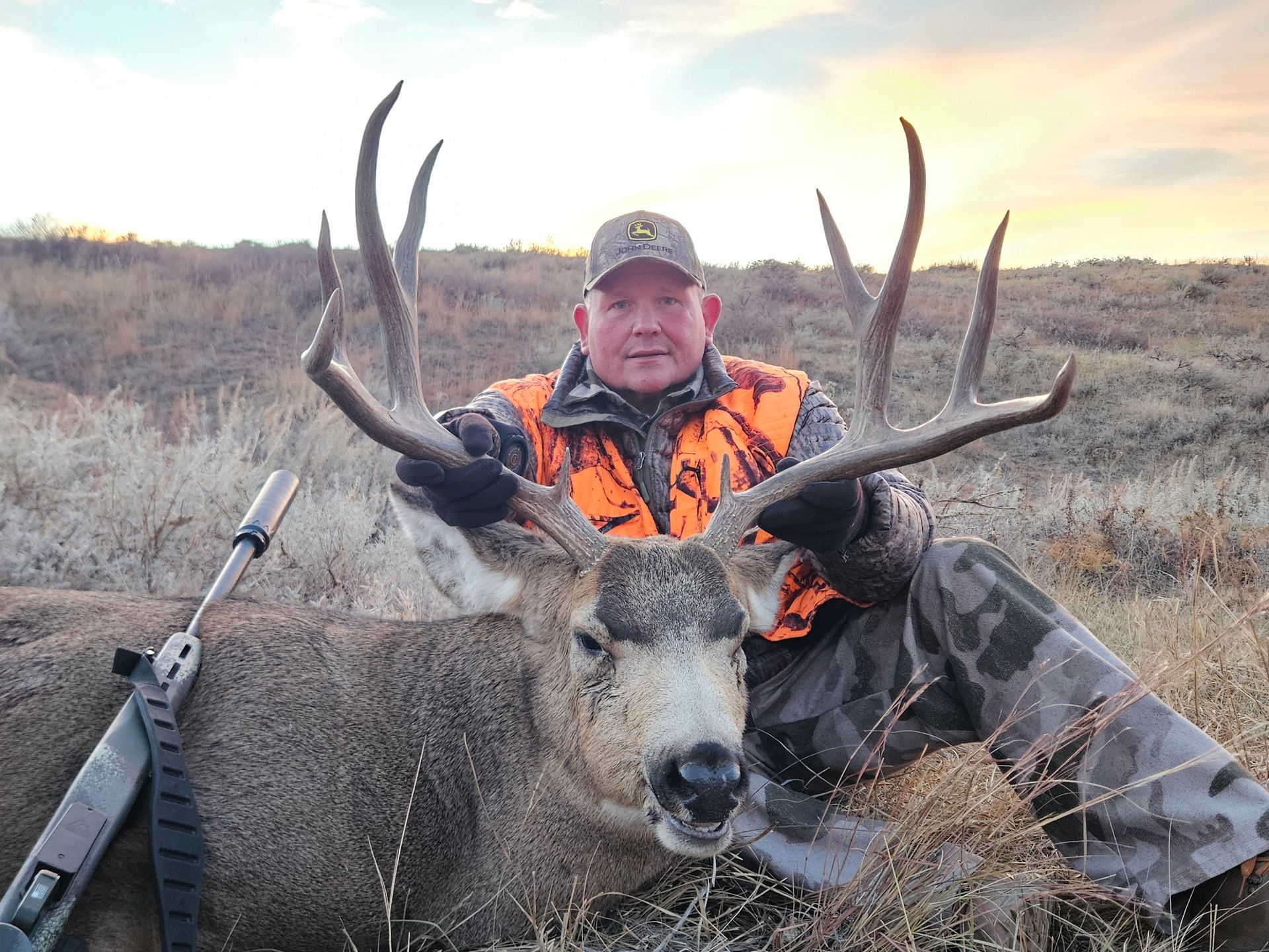 A main holding the antlers of a dead deer