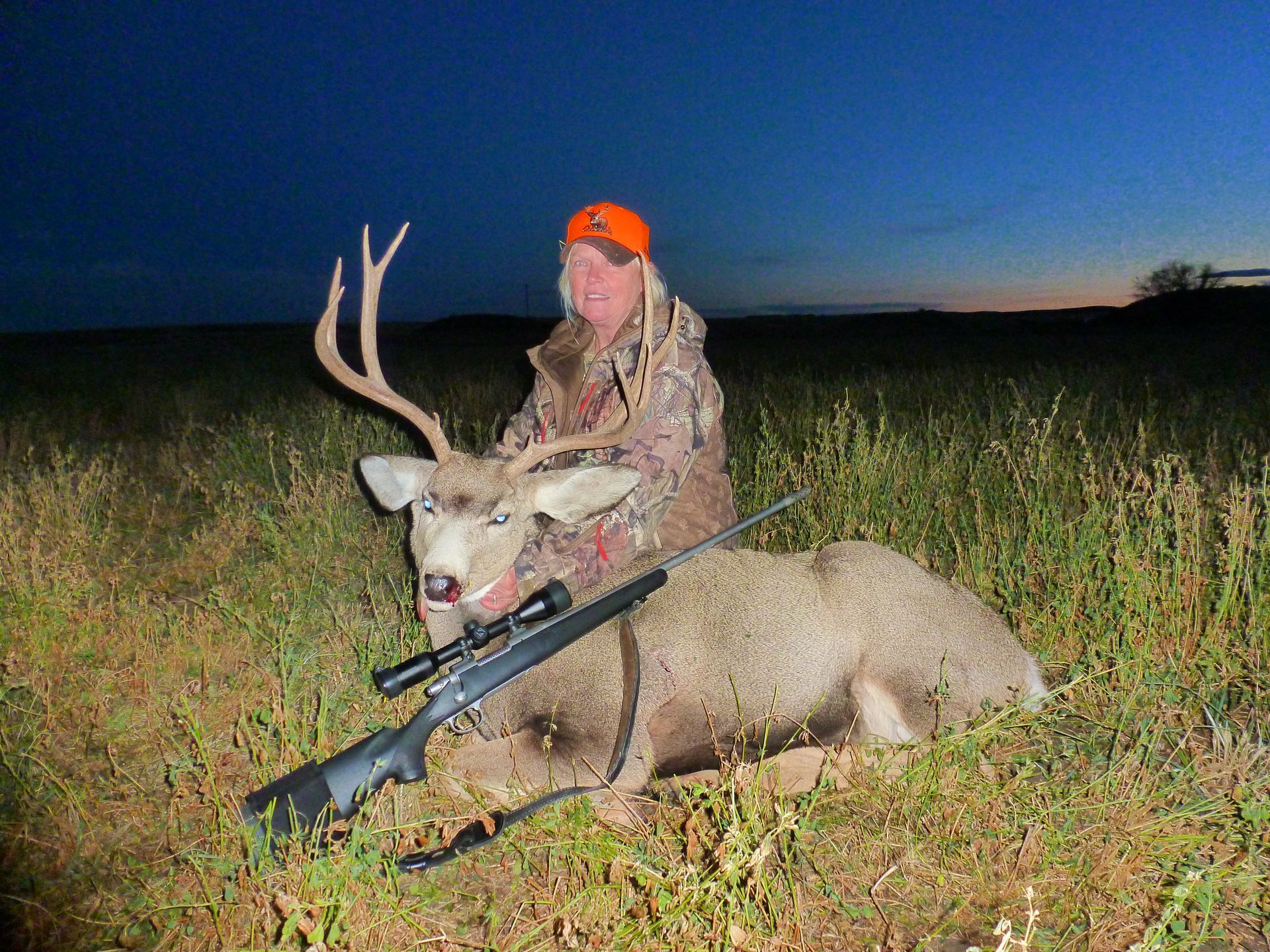 A woman smiling with a dead deer