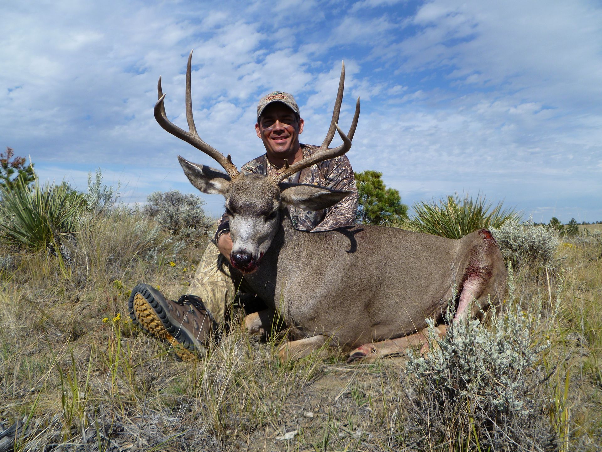 A man smiling with a dead deer