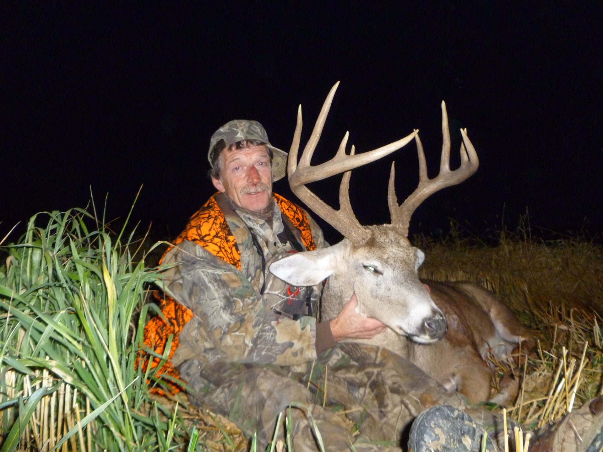 A man posing with a dead deer