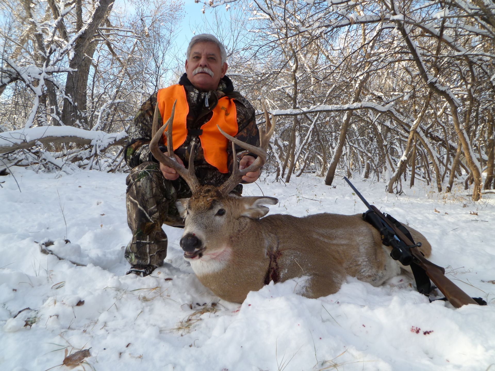 A man holding up a dead deer