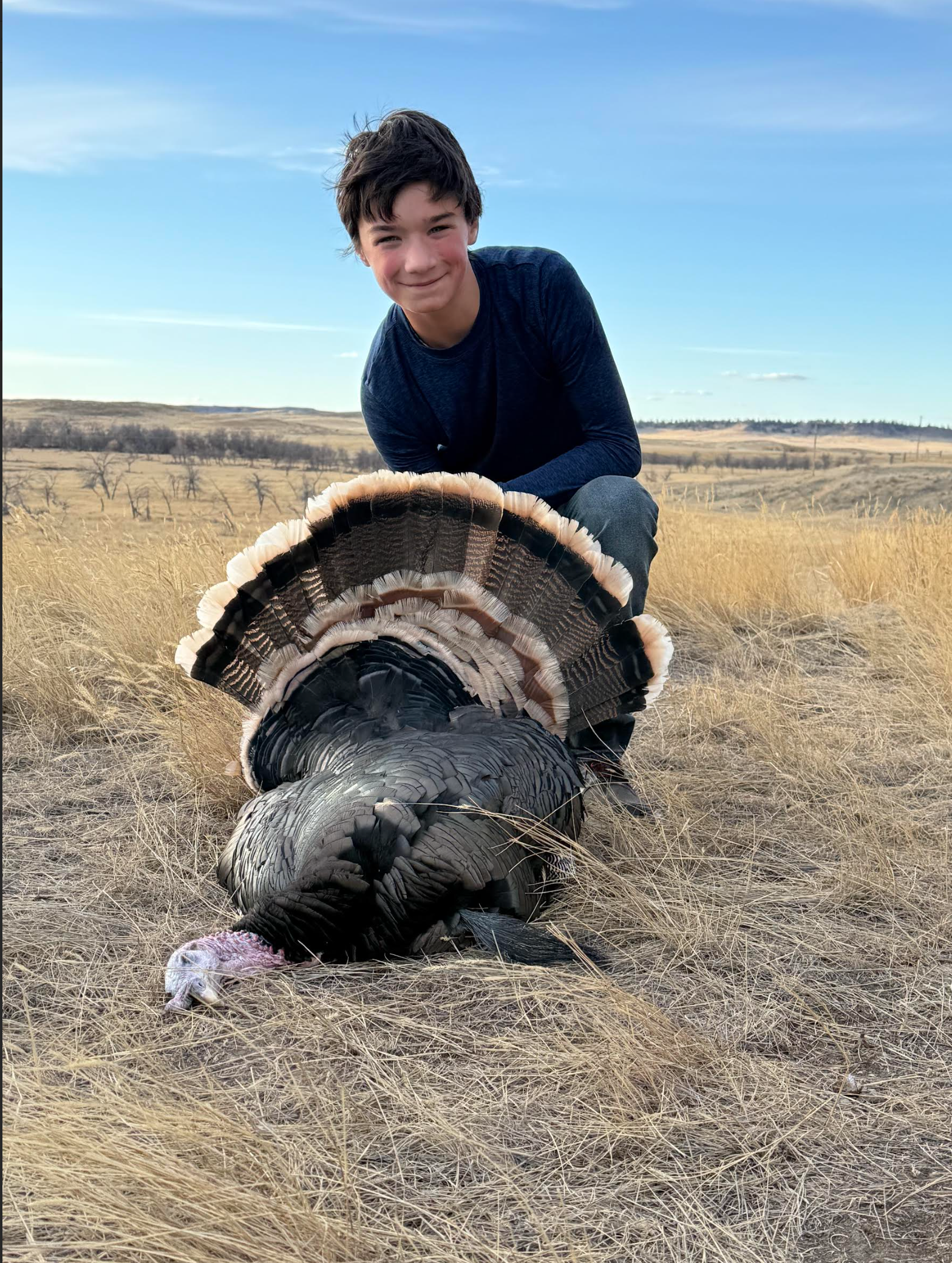 A man posing with a dead turkey