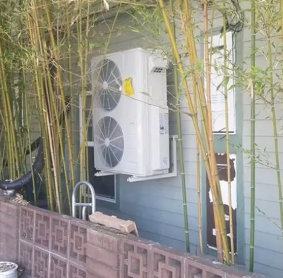 A large air conditioner is mounted on the side of a building