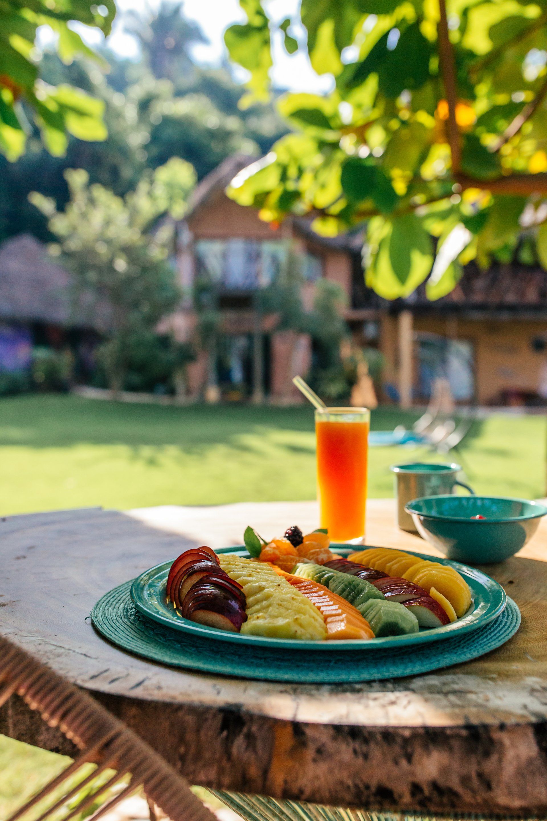 Un plato de comida y un vaso de jugo de naranja en una mesa.