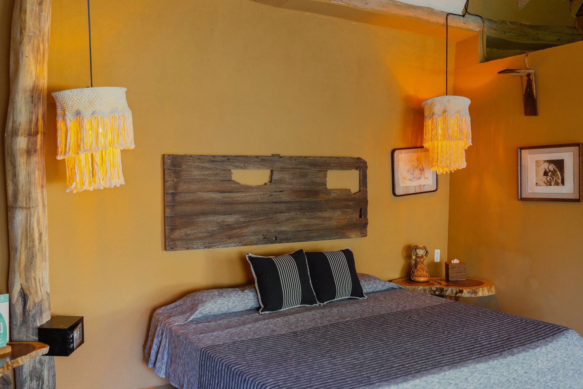 A bedroom with a bed , two lamps and a wooden headboard.