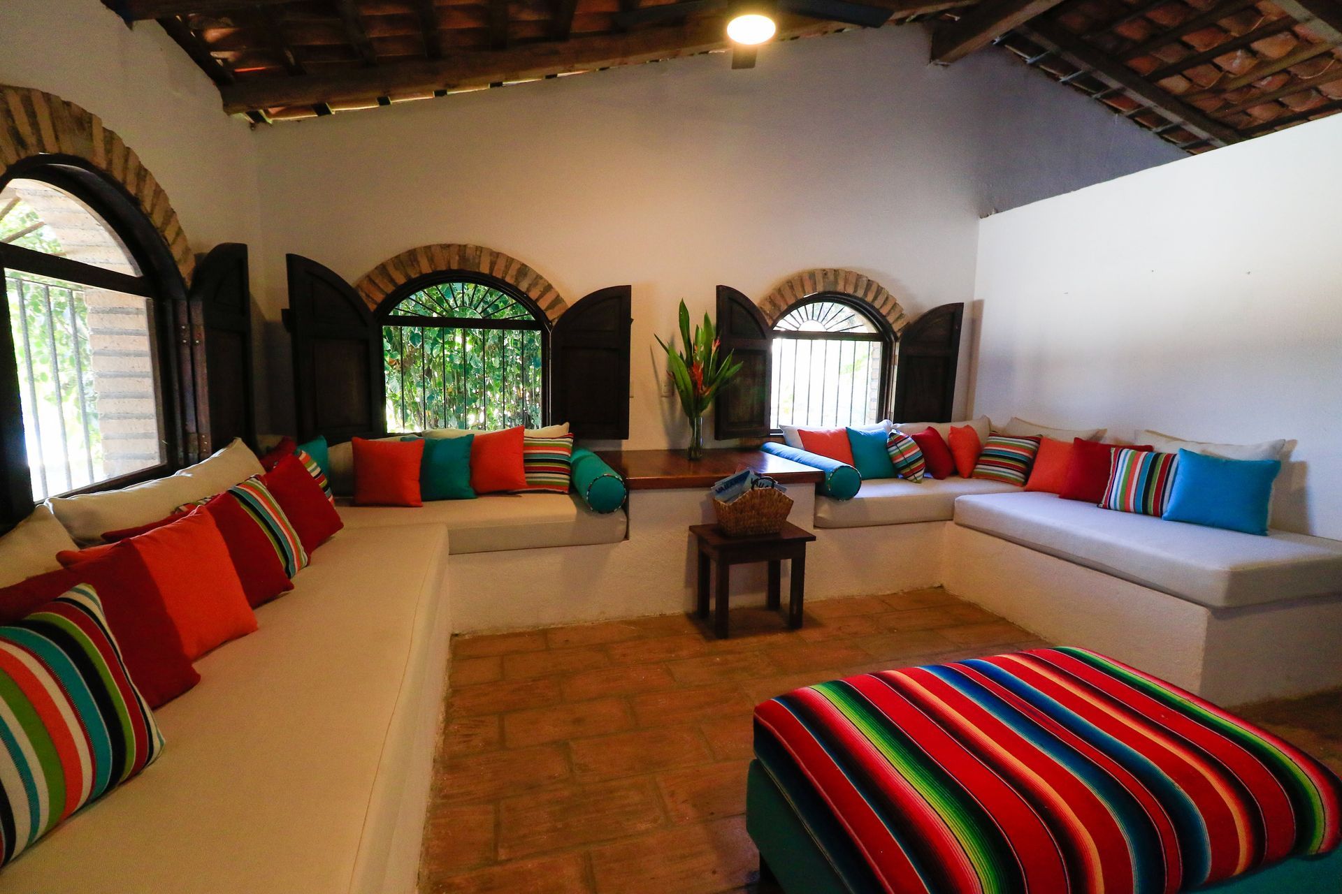 Una sala de estar con muchos cojines de colores en el sofá.