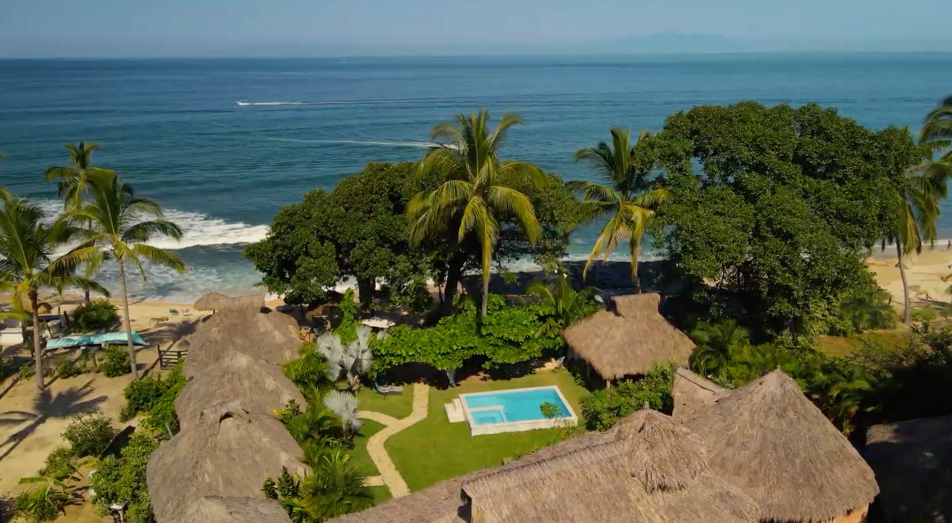 An aerial view of a tropical resort with a swimming pool