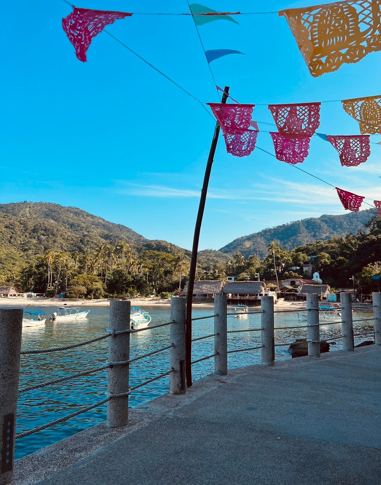 A row of paper flags hanging over a body of water