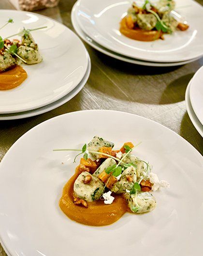 Parsley infused gnocchi with pumpkin puree, Danish feta, & pine nuts