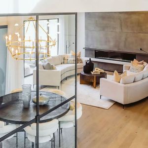 A living room with a couch , table , chairs and a fireplace.