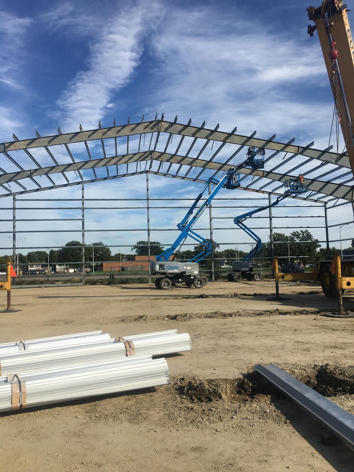 A large metal structure is being built on a construction site.