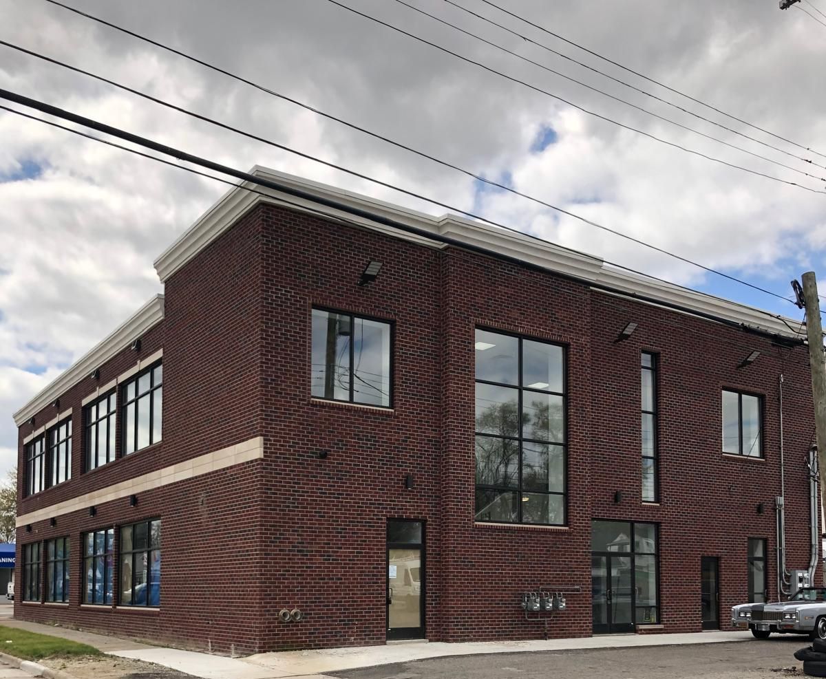A large brick building with a lot of windows on a cloudy day