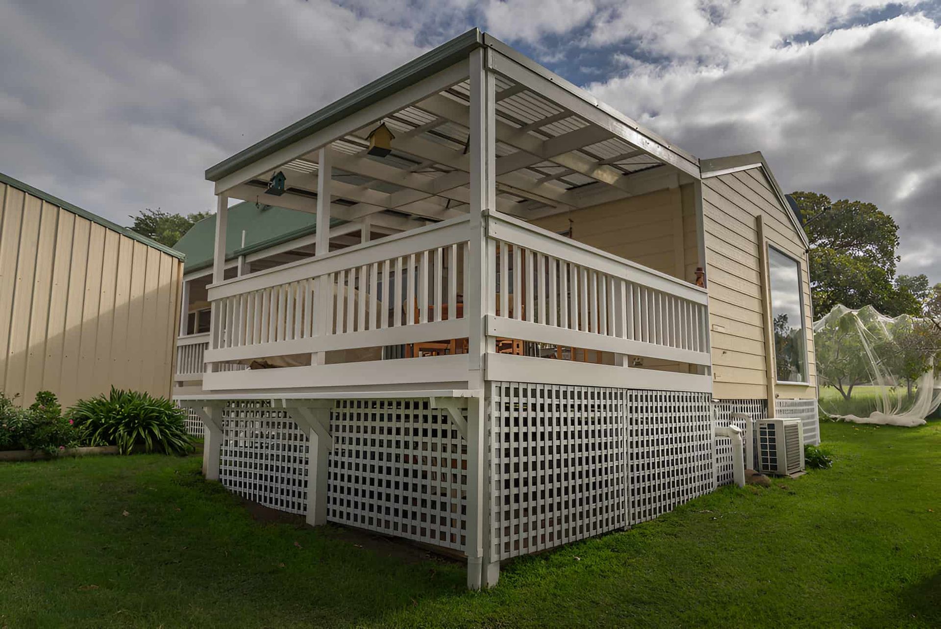 A Small House With a Porch and a Fence — Pride Carpentry & Maintenance In Lake Macquarie, NSW