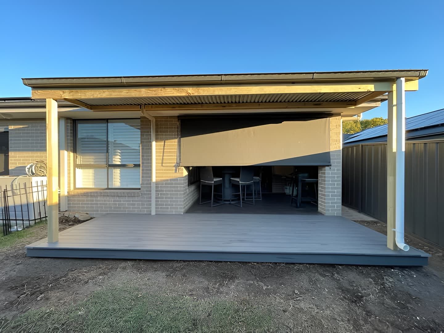 A Deck With a Covered Patio and a Table — Pride Carpentry & Maintenance In Berkeley Vale, NSW