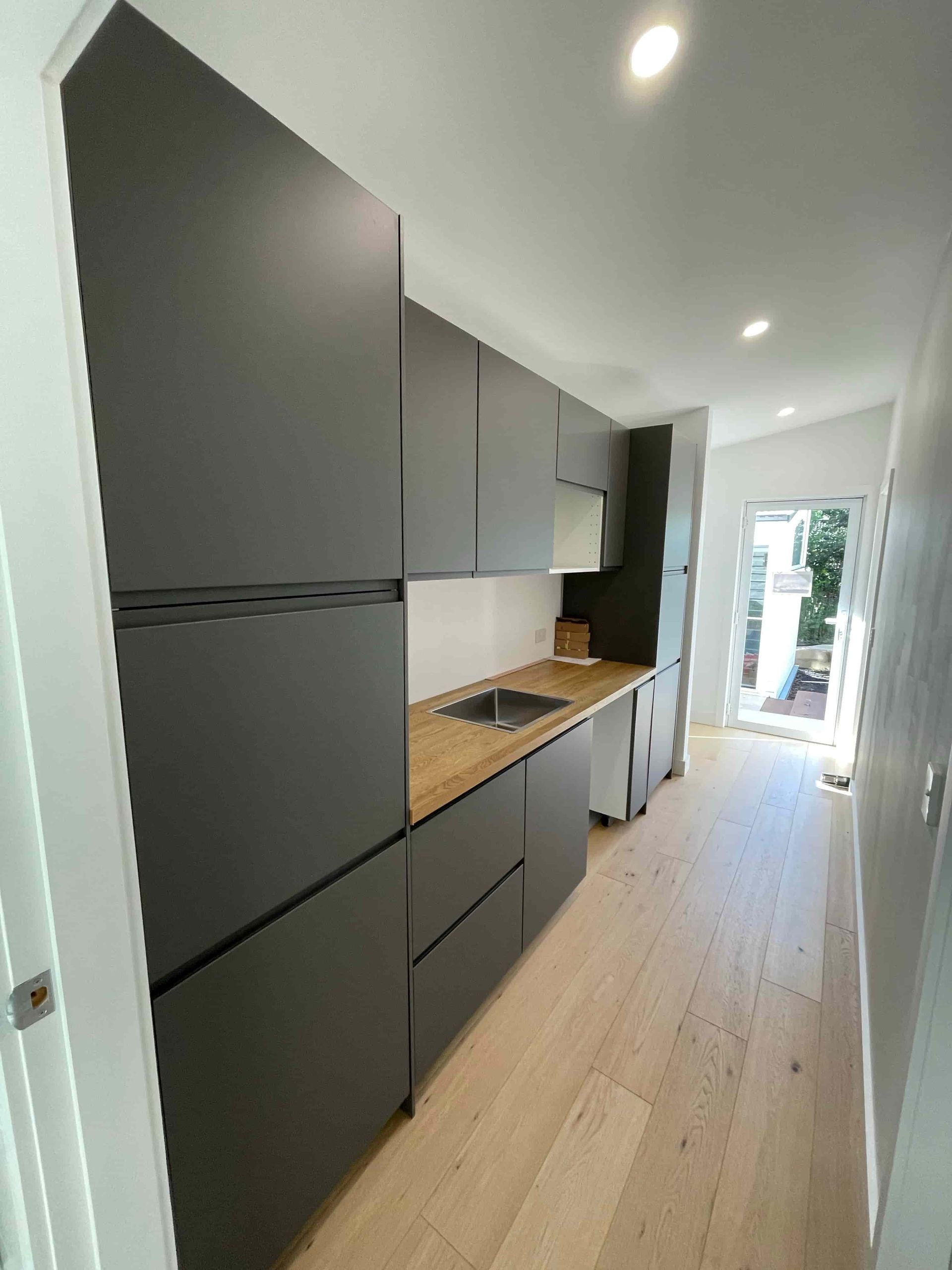 A Kitchen Interior With Cabinets and Wooden Floors — Pride Carpentry & Maintenance In Berkeley Vale, NSW