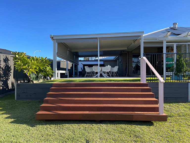 A Cozy Patio Under a Pergola — Pride Carpentry & Maintenance In Berkeley Vale, NSW