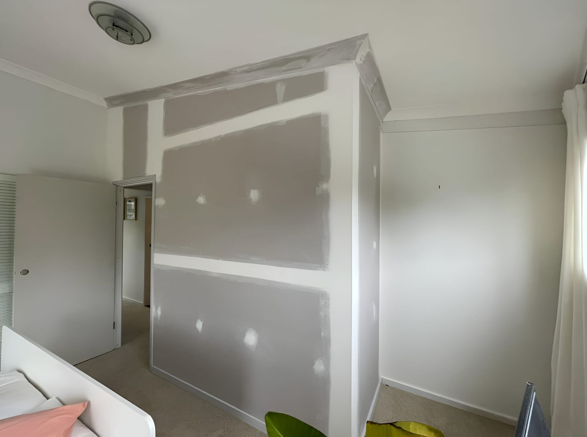 A bedroom with a couch and a plant in it. — Pride Carpentry & Maintenance In Central Coast, NSW