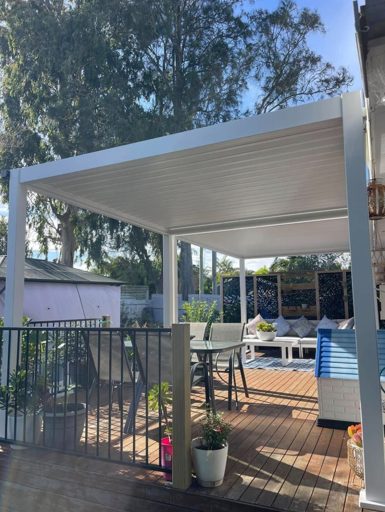 White Pergola With a Table and Chairs on a Deck — Pride Carpentry & Maintenance In Berkeley Vale, NSW