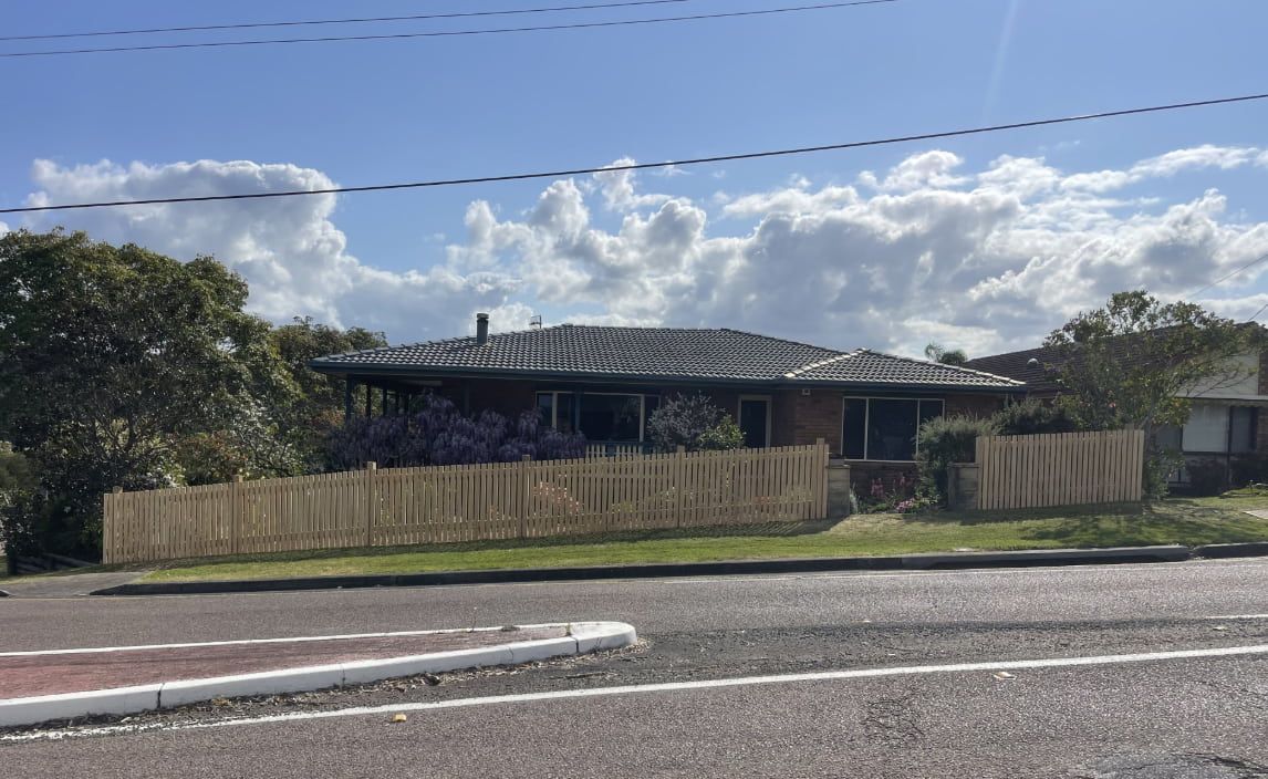 A House Surrounded by a Fence — Pride Carpentry & Maintenance In Berkeley Vale, NSW