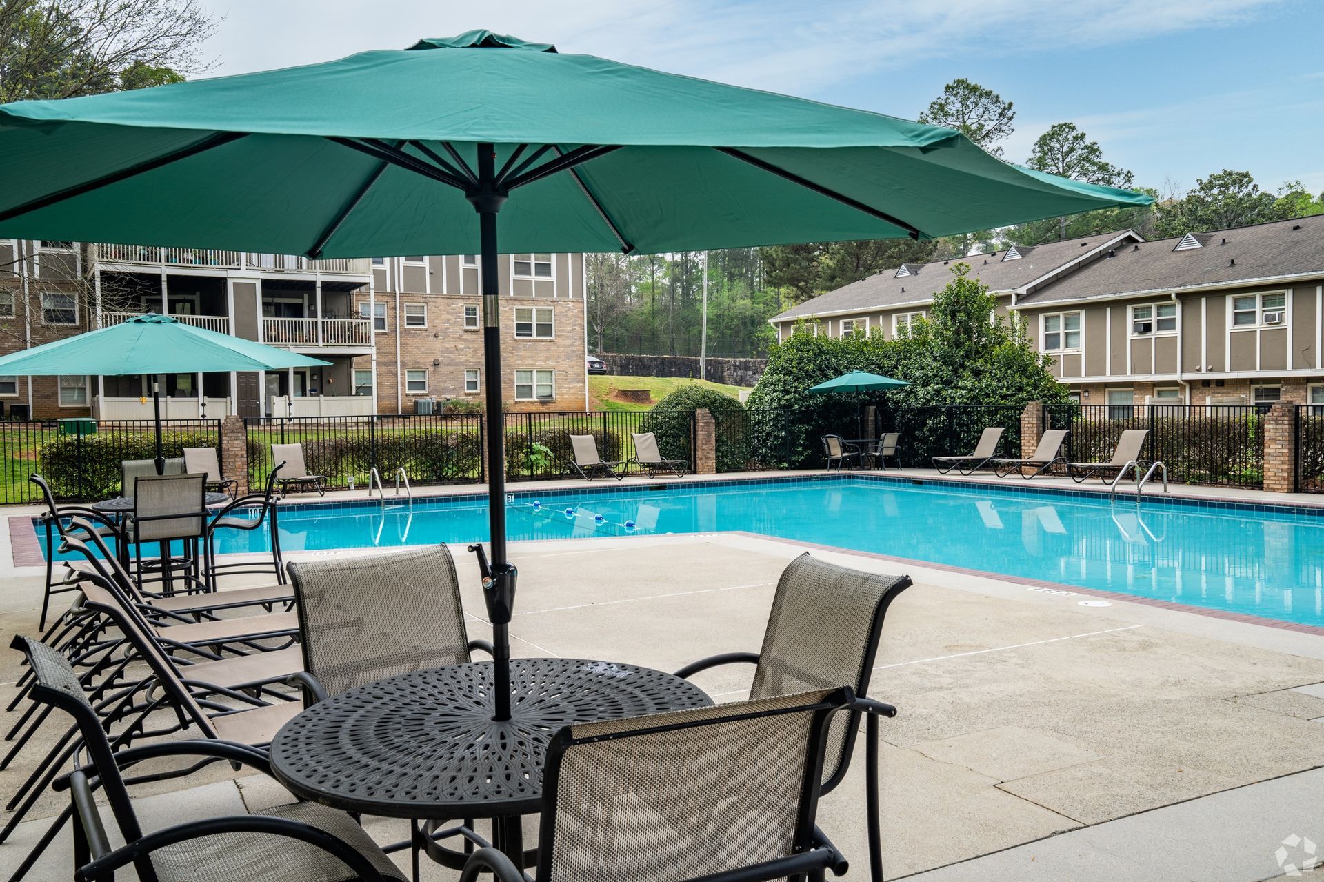 swimming pool with tables and umbrellas for shade