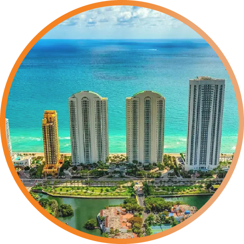 Oceanfront high-rise condos with turquoise sea and a marina in the foreground