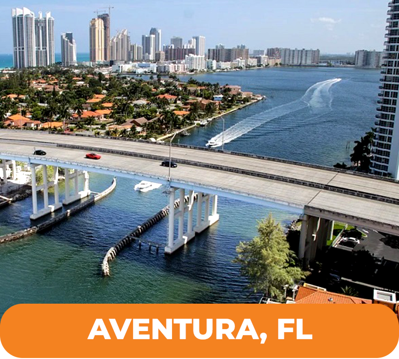 Aventura, FL waterfront scene with bridge, buildings, boats, and blue water.