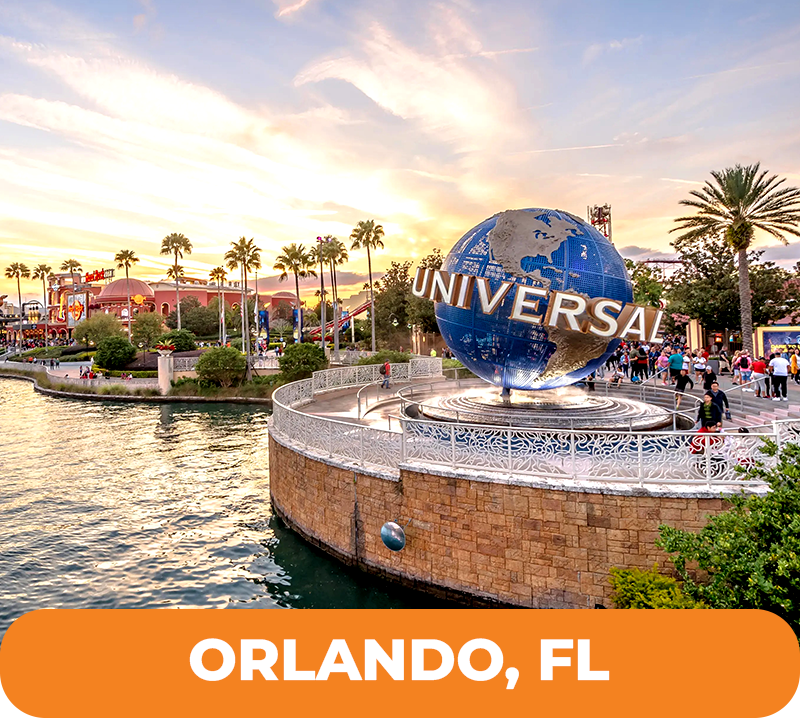 Universal Globe landmark in Orlando, Florida, with sunset sky and water. People walking around.